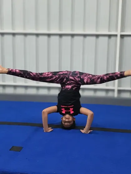 Holding a middle split while in a headstand is an incredible display of strength, balance, and flexibility that our students work towards.