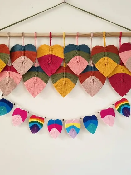 A full wall display of our colorful macrame leaf hangings and a matching leaf bunting. This shows the versatility of our smaller decor pieces.
