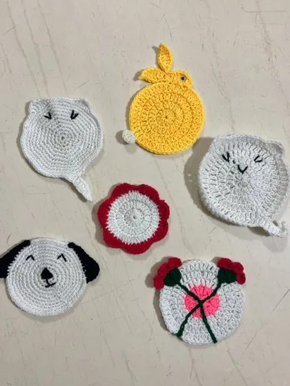 A set of whimsical, custom-made tea coasters featuring cute animal faces like cats and a dog, alongside a bunny and floral designs.