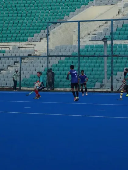 A wide view of the match, showing the strategic spacing of players across the field. We train our teams to maintain their structure during open play.