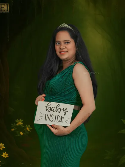 A fun studio shot using a "Baby Inside" sign, set against an enchanted forest backdrop.