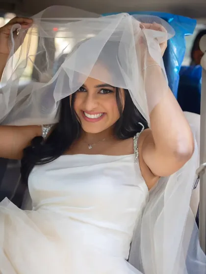 A playful peek from under the veil. This bride's bright smile and simple, elegant style are just perfect.
