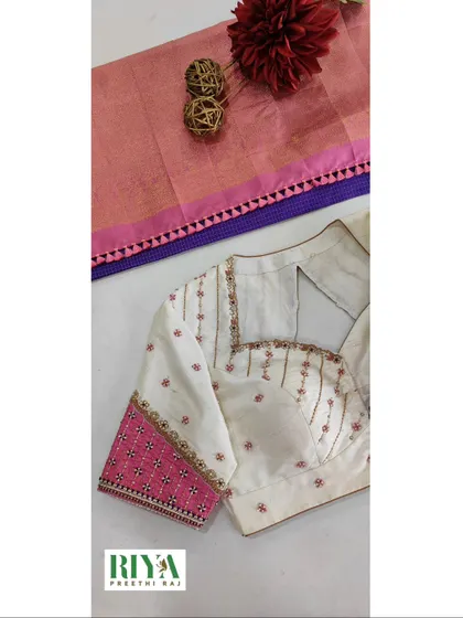 This image shows the full front and sleeve detail of the pretty contrast blouse. The clean lines of the neckline and the intricate embroidery on the sleeve create a balanced and elegant design, perfect for pairing with a simple silk saree.