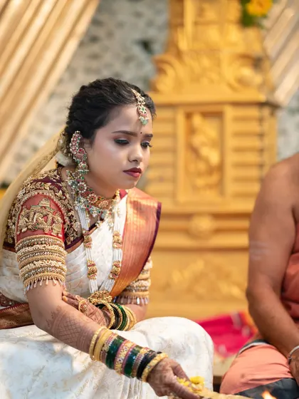 A candid moment from Lavanya's Muhurtham ceremony. Her makeup was designed to be timeless, with a classic red lip and defined eyes that photograph beautifully while honoring tradition.