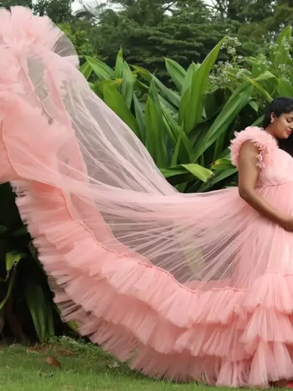A side view of the pink maternity gown, showcasing the beautiful cascade of ruffles.