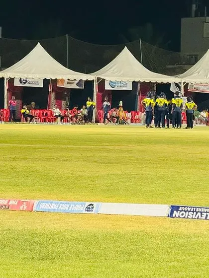 Our facility is fully equipped to host tournaments at night. This image showcases the combination of bright floodlighting and organized tent setups for teams during an evening event.
