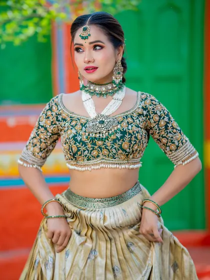 Another angle of this gorgeous bridal look, highlighting the intricate embroidery on the blouse and the heavy, layered jewelry that perfectly complements the outfit.