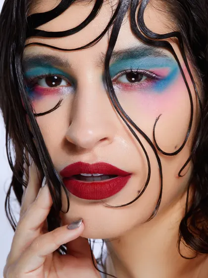 A colorful, painterly eye makeup look with a wet-look hairstyle, demonstrating a high level of artistic skill.