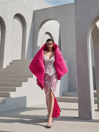 A fully embellished corset and slit skirt in a dreamy pink hue, detailed with delicate pearls and finished with a quilted coverup for a touch of luxe.