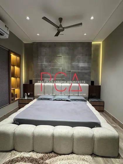 This is the son's bedroom in a recently completed residence, designed with a bold and masculine palette. The room features a custom bed upholstered in beige bouclé fabric set against a geometric, antique silver-finished accent wall, showcasing my ability to create personalized and stylish private spaces.