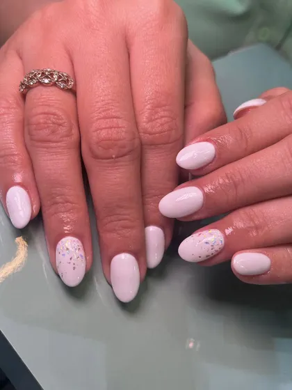 A simple and clean look featuring a soft, milky white gel polish. For a touch of sparkle, we added a subtle glitter effect to the accent nail.