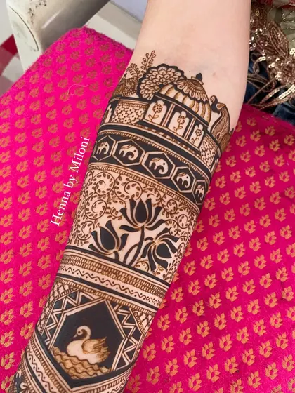 A full-arm design with a variety of traditional motifs. It includes a swan, elephants, lotuses, and architectural elements.