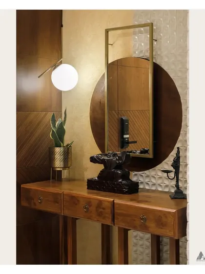 We designed this foyer to create a sense of sophistication upon entry. A sleek wooden console table is accented with layered mirrors, a modern pendant light, and curated sculptures.