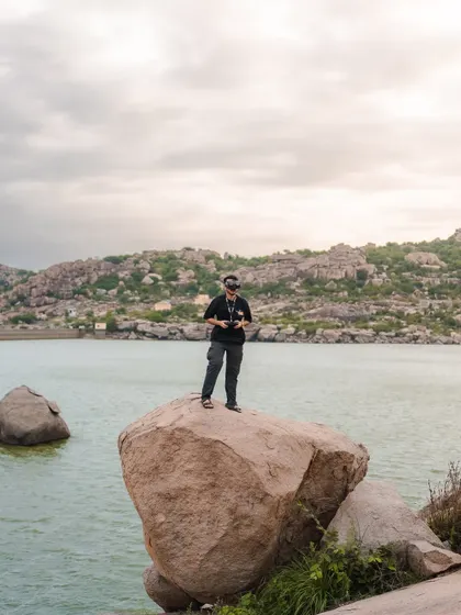 A shot of me in my element, standing on a rock by the water, ready to fly. Finding epic locations is a huge part of the adventure.