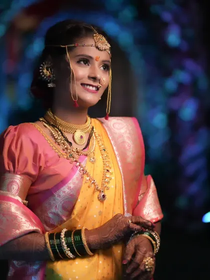 The quintessential Maharashtrian bride. This close-up highlights the traditional crescent bindi, the glow of HD makeup, and the intricate details of the nath and gold jewelry that are central to this beautiful look.