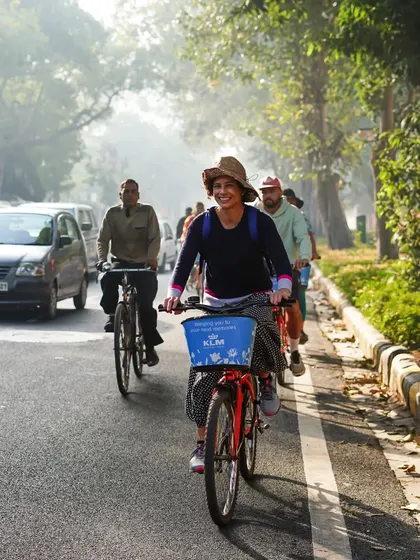 The simple joy of cycling on a sunny day in Delhi. This rider's smile captures the carefree feeling of exploring the city on two wheels.