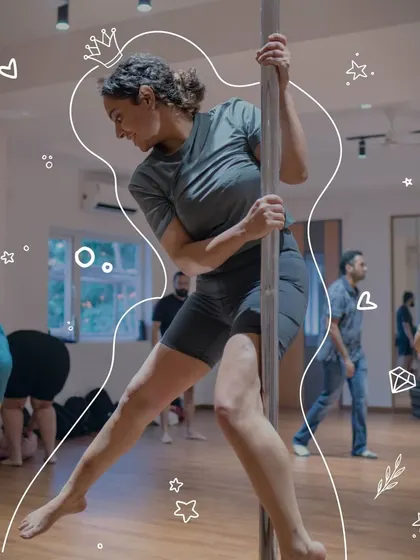 A participant smiles as she masters a new spin. Our pole movement workshops celebrate progress at every level, building confidence with each new skill learned.