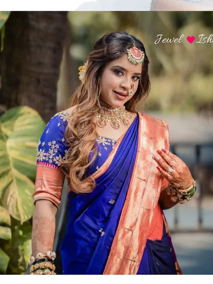 A portrait of our stunning bride Aishwarya for her Sakharpuda. She is wearing a traditional temple jewellery choker, jhumkas, and a bindi-style maang tikka with her royal blue Paithani saree.