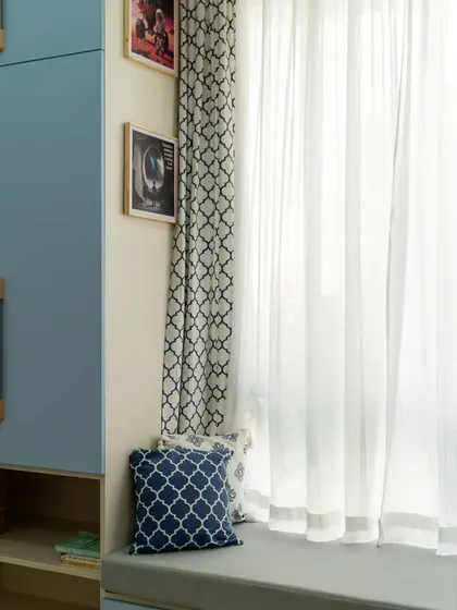 A cozy window seat with storage underneath, surrounded by a large wardrobe unit. It's the perfect spot for reading or looking out the window, with comfortable cushions adding to the appeal.