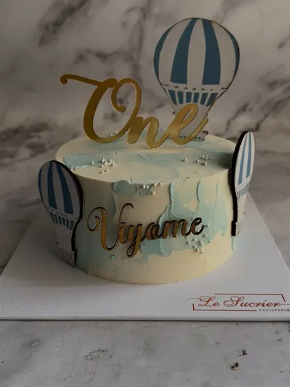 Up, up, and away! This charming hot air balloon cake is perfect for celebrating a little one's first journey around the sun, with custom toppers and a dreamy, sky-blue design.