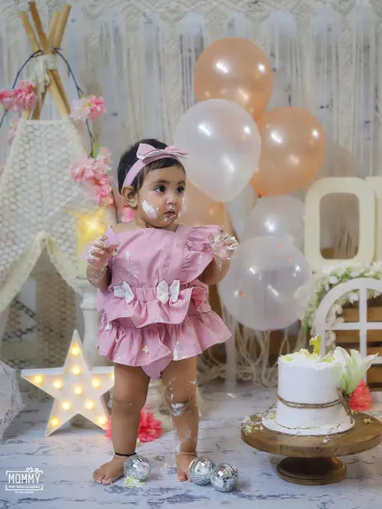 This little girl is so excited to stand and get her hands on that beautiful cake in her dreamy pastel-themed setup.