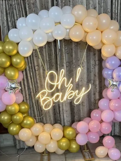 An "Oh Baby" welcome home ring in a mix of pastel colors. The neon sign in the center adds a modern touch to the celebration.