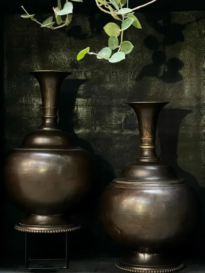 Two large copper vases with a vintage finish, perfect for creating a symmetrical and elegant display. Their classic shape and substantial size make them a great addition to an entrance or living room.