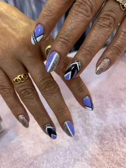 A modern geometric design with a mix of lavender, black, white, and silver glitter polish.