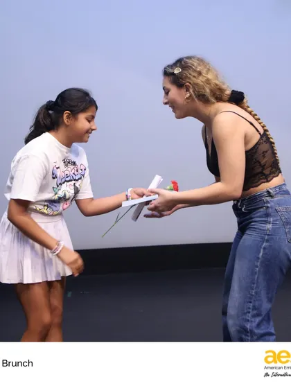 A senior receives a thoughtful gift from a younger 'buddy' student during the Senior Brunch. This tradition fosters connections across grade levels and creates a touching, full-circle moment for our graduates.