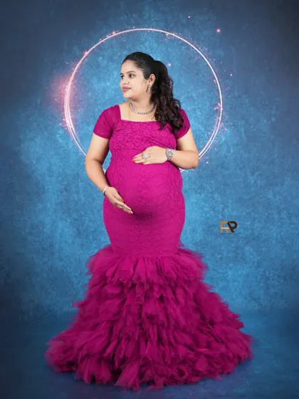 A stunning mermaid-style gown in a vibrant magenta. The ruffled bottom adds drama, while the fitted top beautifully accentuates the baby bump.
