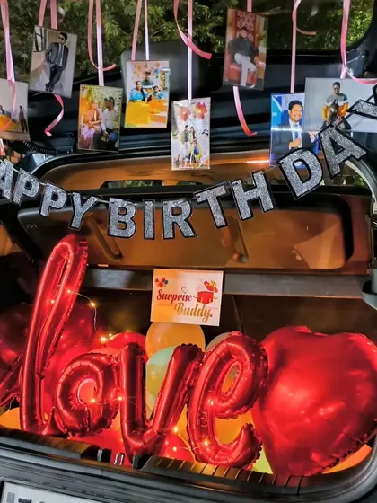 Another romantic car dikki decoration, with a large "Love" foil balloon, red heart balloons, and a banner of photos.