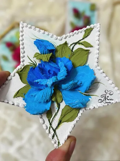 A star-shaped fridge magnet with a beautiful blue rose, a unique and eye-catching design.