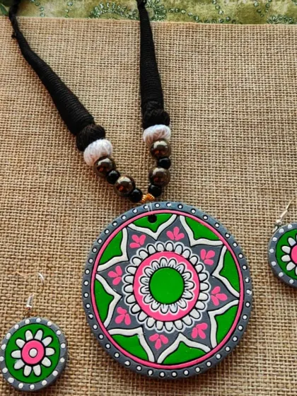 A green, pink, and grey version of the mandala pendant necklace.