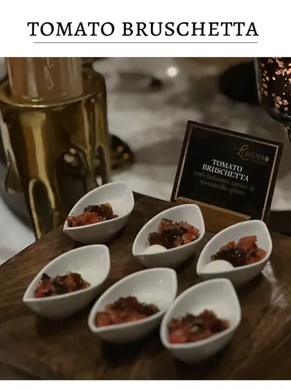 Classic tomato bruschetta served in individual, modern ceramic spoons. The fresh tomato and basil topping sits on a small piece of mozzarella for a creamy finish.
