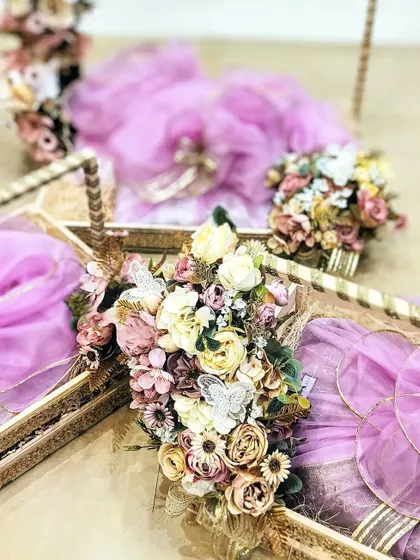 This pretty wedding trousseau showcases my love for pastel hues. The gifts are packed in elegant trays and wrapped in lavender fabric, adorned with delicate floral bouquets for a soft, romantic look.