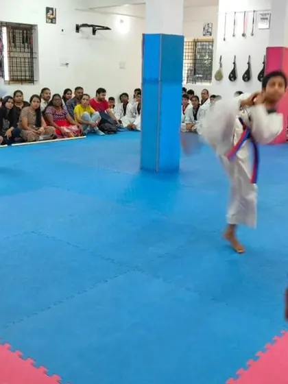 A student executes a jumping kick during her belt exam.