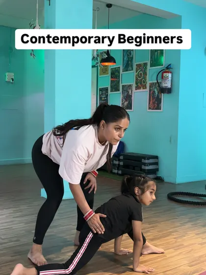 A close-up of an instructor correcting a student's form in a lunge, highlighting the focus on technical excellence.
