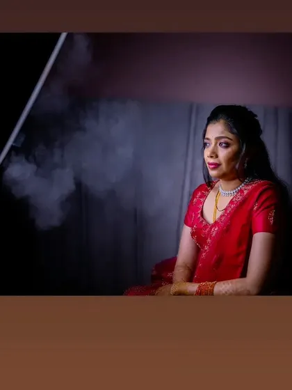 A dramatic and artistic shot of Vasudha during her reception photoshoot. The lighting highlights her contemplative expression and the beautiful makeup.