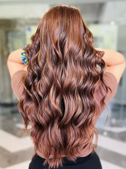 Rich hazelnut hues styled into beautiful, bouncy waves. This look showcases our expertise in creating warm, dimensional brunette colors that are full of life and shine.
