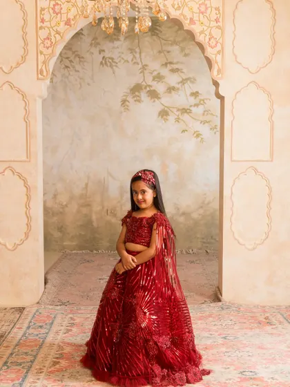 This vibrant red lehenga is a showstopper, featuring intricate sequin patterns and a matching cape for a touch of modern elegance.