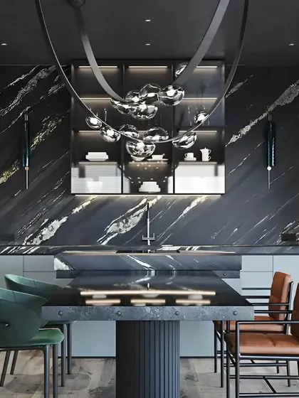 A luxurious and dramatic kitchen and dining area with a black marble accent wall and island. The unique, modern chandelier acts as a stunning centerpiece.