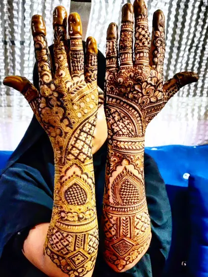 A beautiful example of symmetrical bridal henna, with mirror-image patterns on both hands.