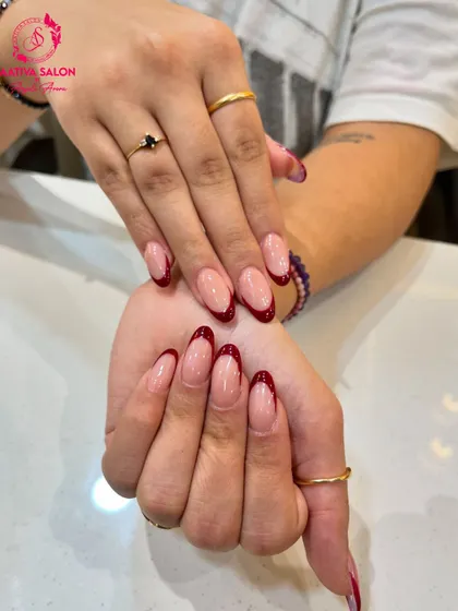 A close-up of our red French tip nails, showing the glossy finish and perfect almond shape. This design is both elegant and eye-catching.