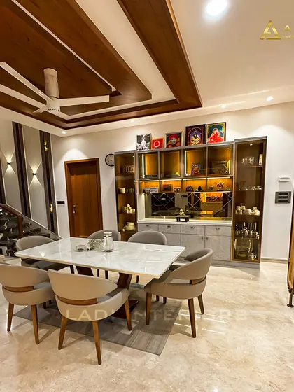 A wide-angle view of the dining and living space, showing how the different elements like the staircase, wall paneling, and furniture come together to create a cohesive and luxurious home interior.