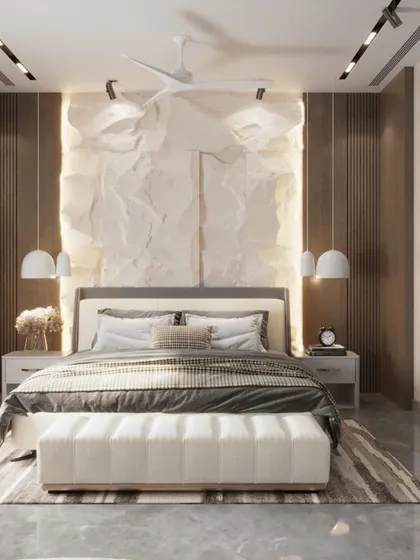 This luxury bedroom is a study in texture and light. A unique, crumpled-paper-effect feature wall is backlit to create a soft glow, while a large abstract artwork adds a bold, modern statement. The result is a classy and artistic personal space.