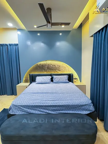 A celestial-themed bedroom with a stunning backlit full-moon headboard as the centerpiece. The deep blue walls and matching furnishings create a dreamy and tranquil atmosphere, perfect for restful nights.