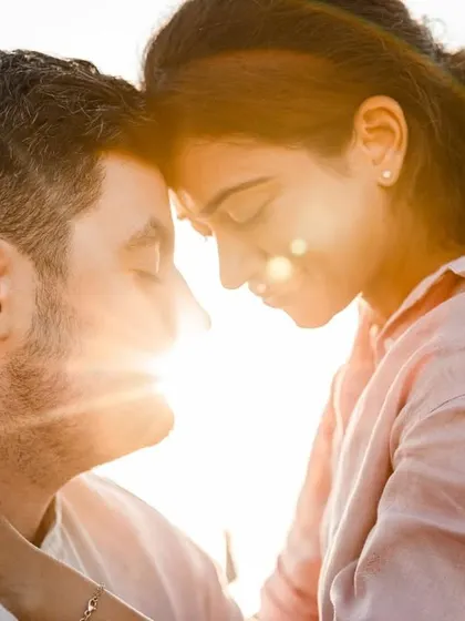 A beautiful sun-flared portrait of the couple in a tender embrace, capturing the warmth and romance of their Malta pre-wedding shoot.