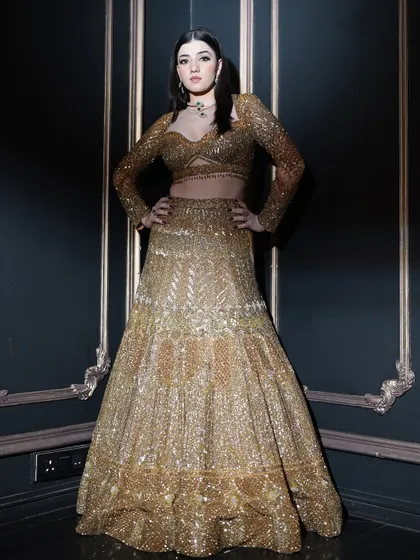 This powerful pose showcases the entire ensemble. The makeup was designed to be dramatic and confident, matching the energy of the heavily embellished golden outfit.