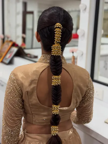 A close-up view of the bubble braid, highlighting the intricate beading of the gold accessories and the flawless finish of the hairstyle.