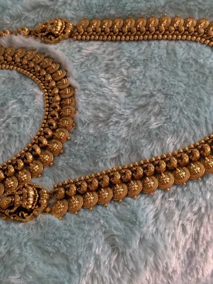 Here you can see the full length of the Laxmi Kaasu necklace and haara combo, laid out to show the craftsmanship. The adjustable cord ensures a perfect fit for any neckline.